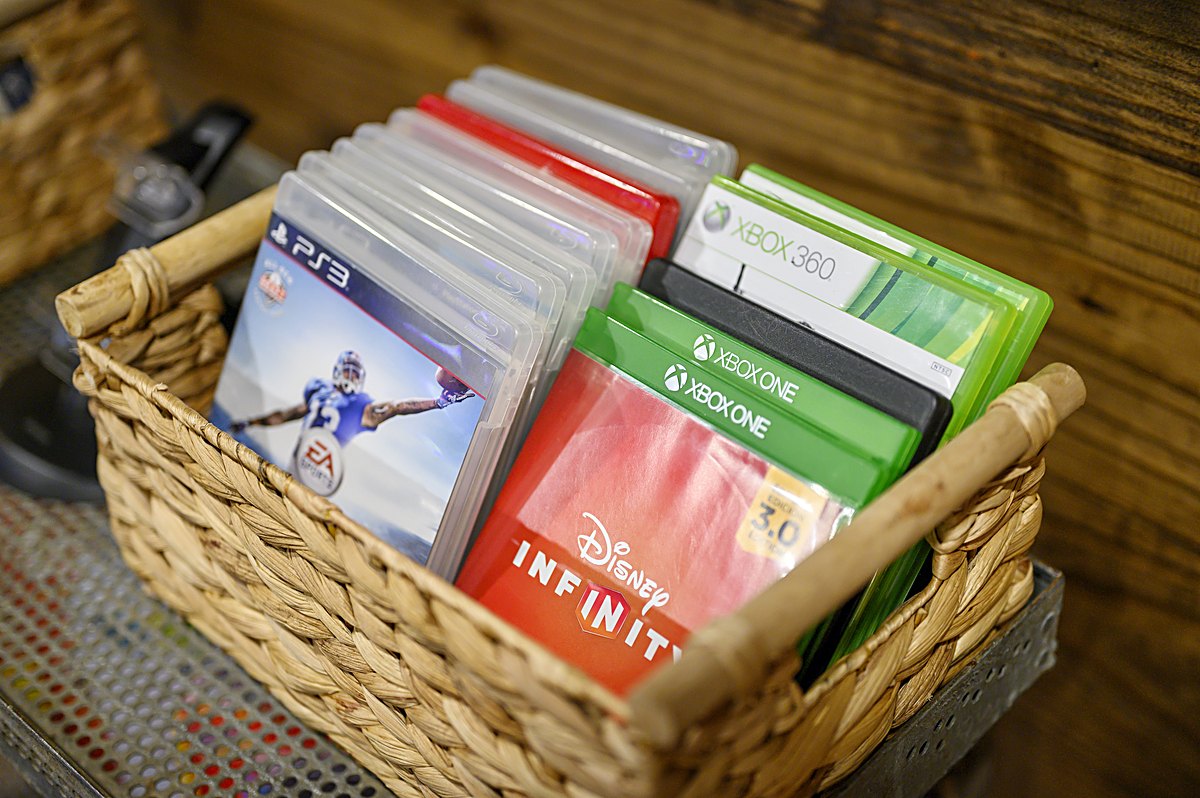 Basket of Xbox and PlayStation games